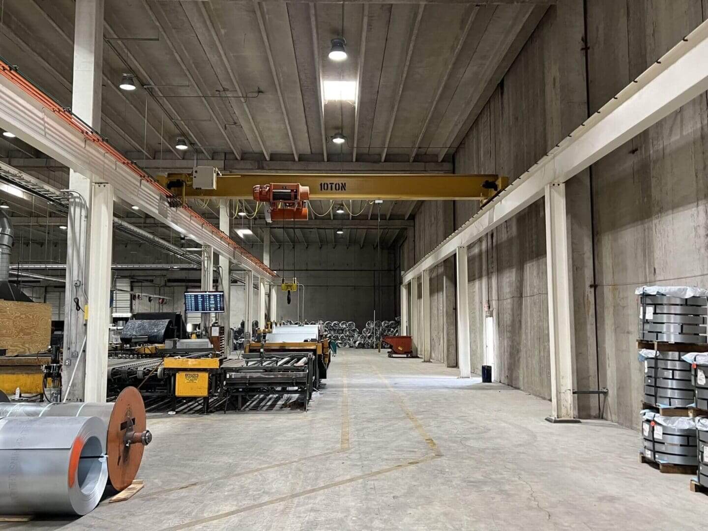 Industrial warehouse with machinery and overhead crane.
